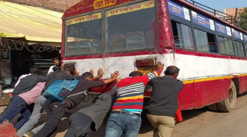 Passengers push the dilapidated buses of Rath depot.